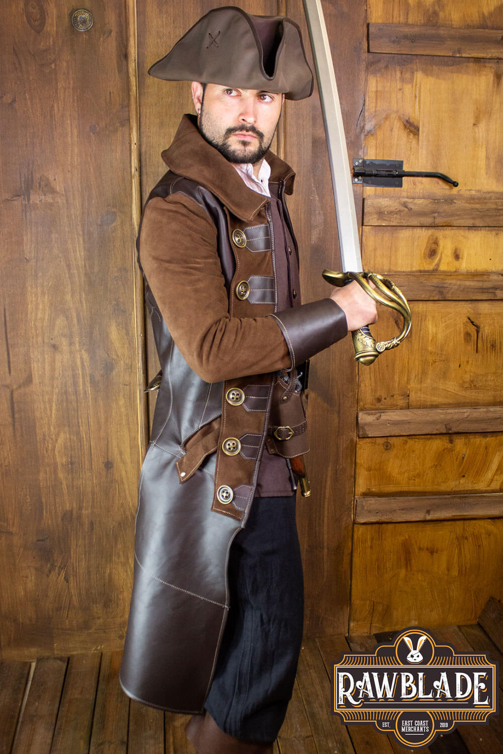 Man wearing a pirate costume from the Rawblade collection, posing with a sword in a rustic setting.