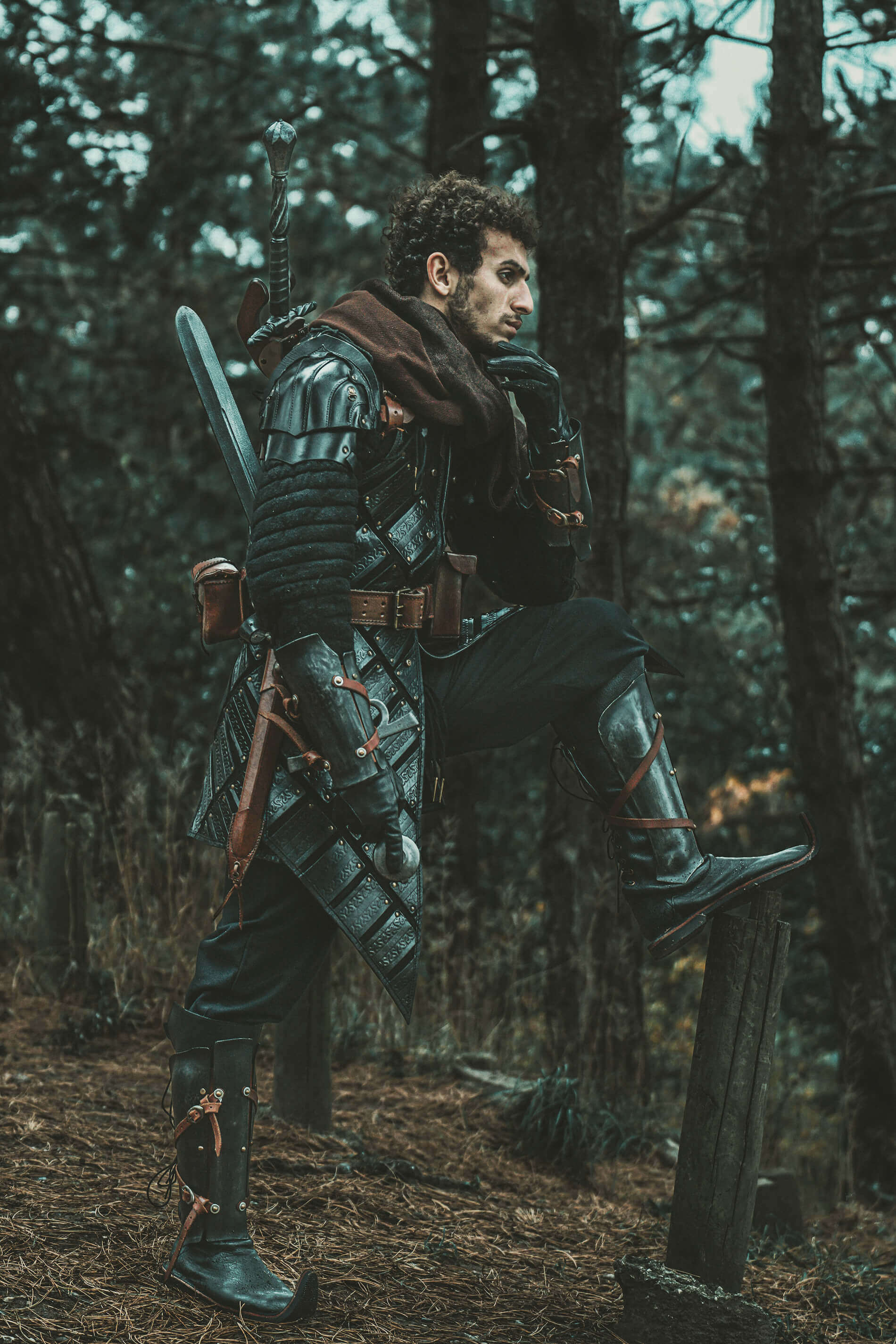 A character in armor pondering in a forest, embodying The Witcher theme.