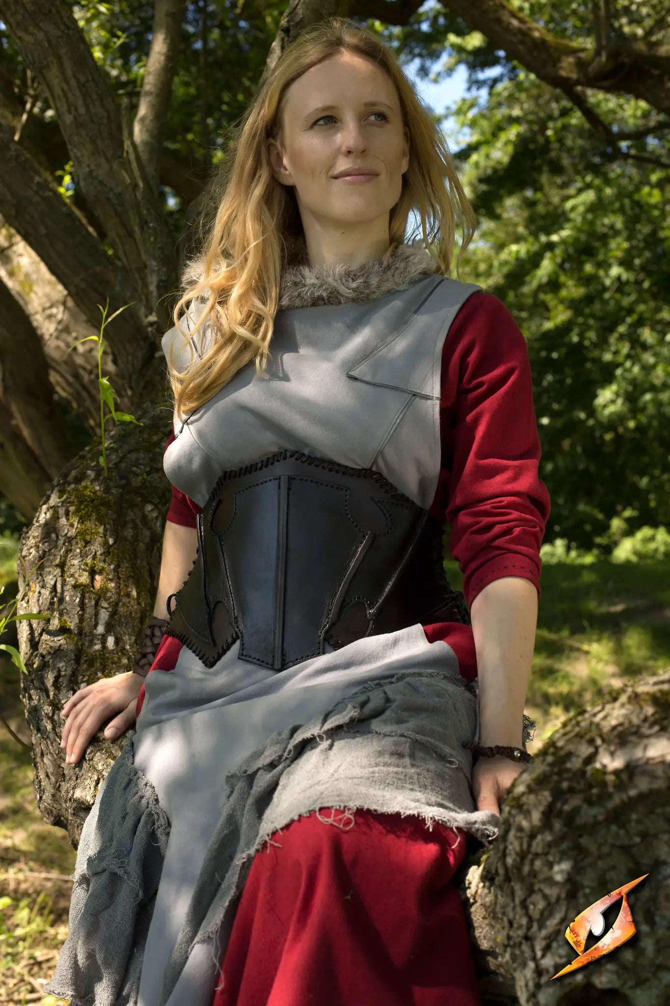 Dark Elf Corset worn by a woman seated on a tree, showcasing its unique design and craftsmanship.
