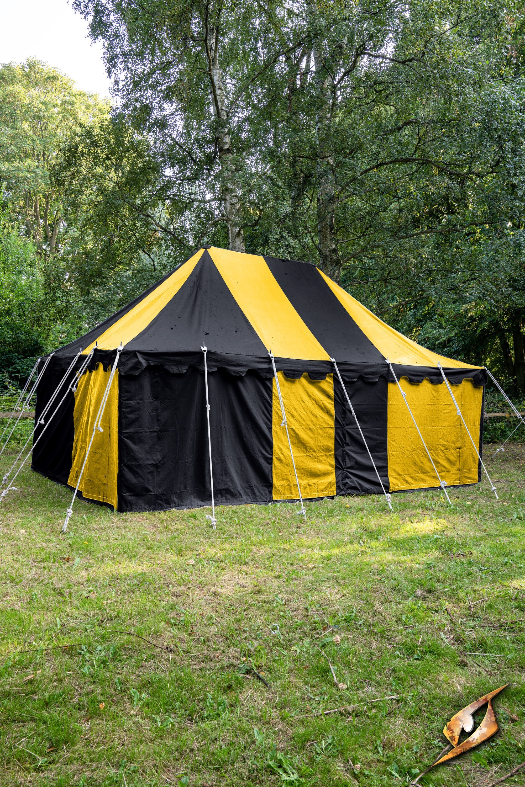 Marquee Tent - 4x6m set among trees with black and yellow striped canvas, ideal for outdoor events and gatherings.