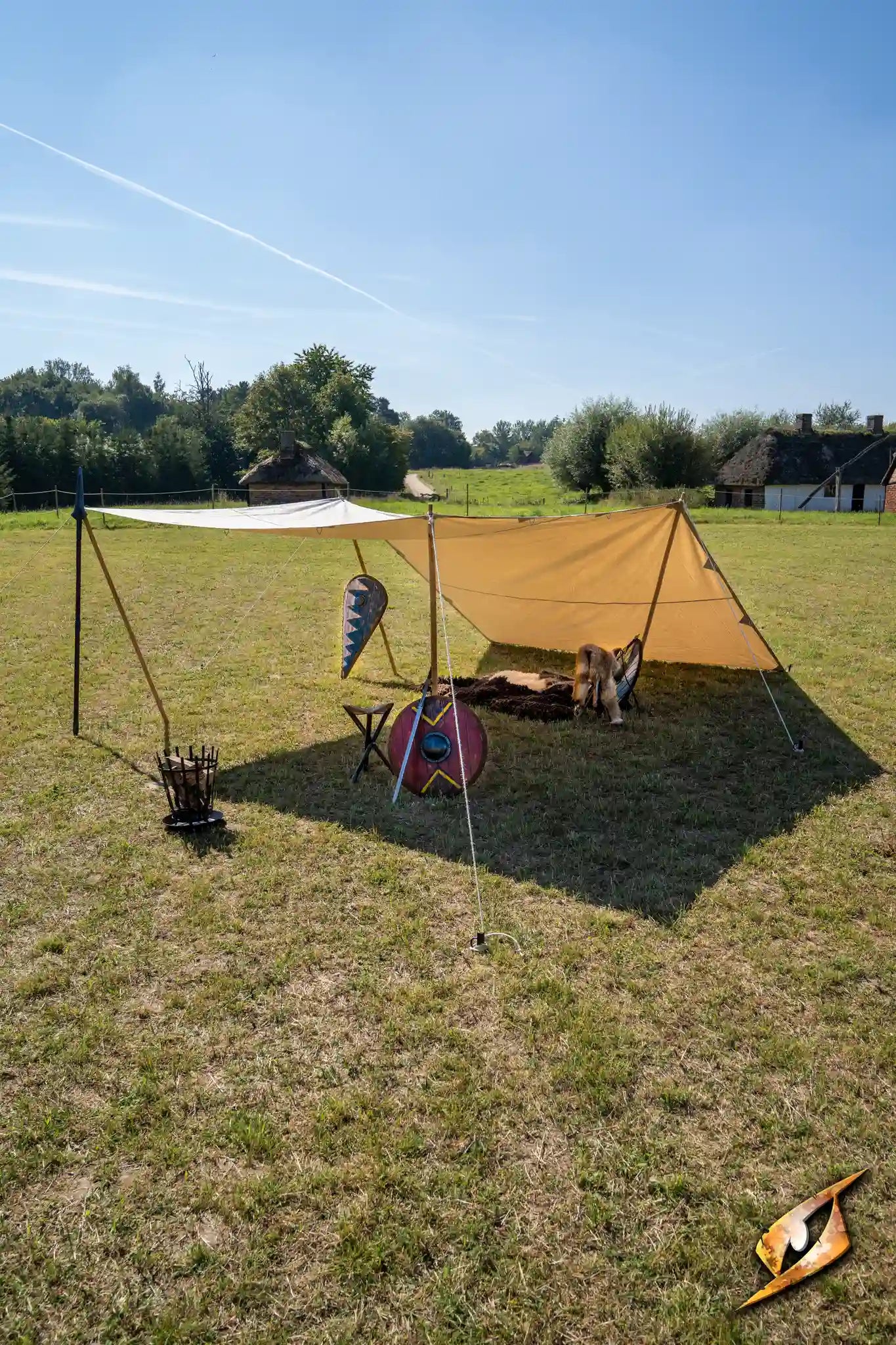 Epic Armoury Tarpaulin setup in a sunny field, showcasing its weatherproof design and versatile usage.