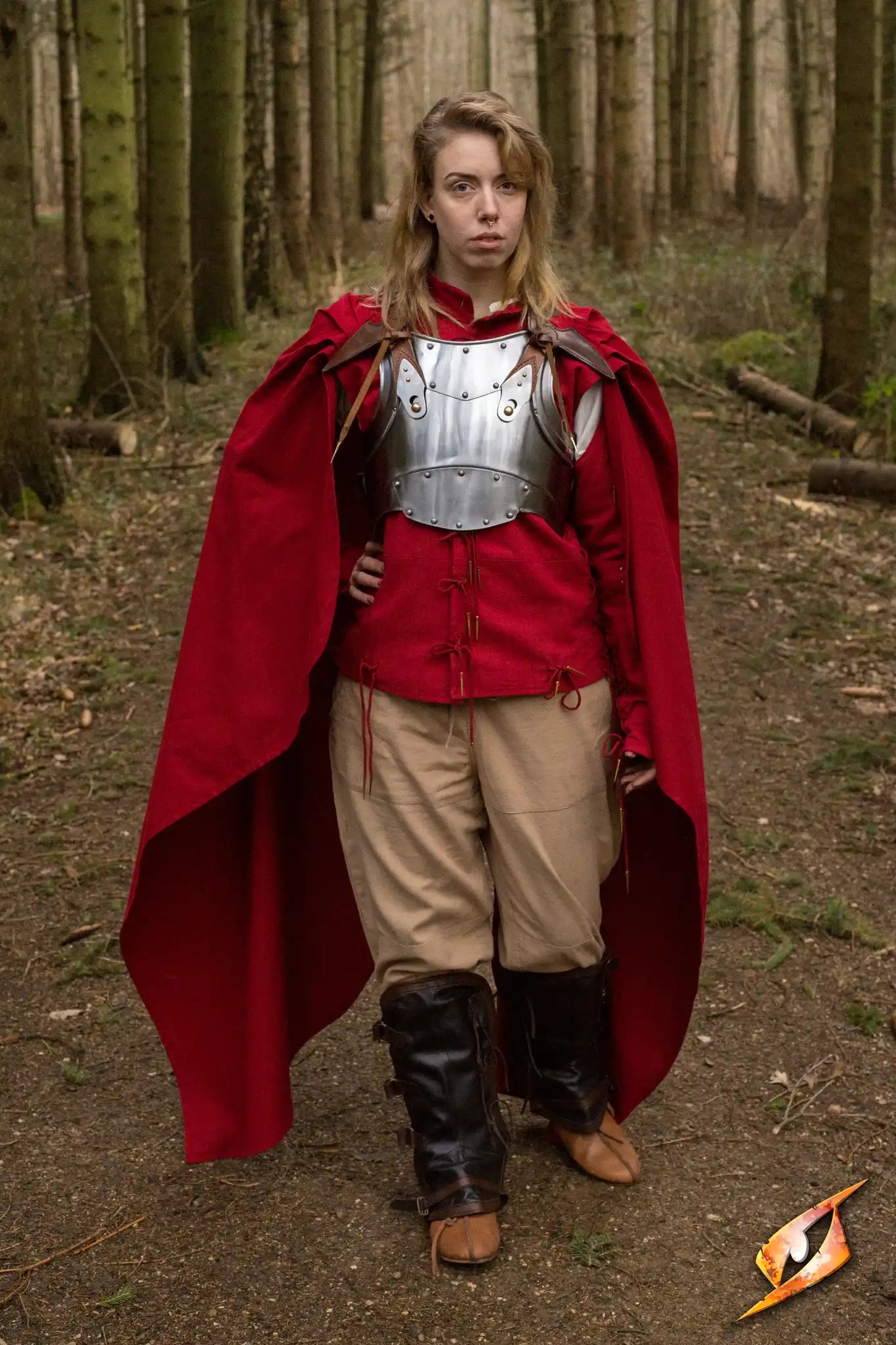 Cape Regulus worn by a model in a forest, showcasing its rich fabric and intricate pleated collar.