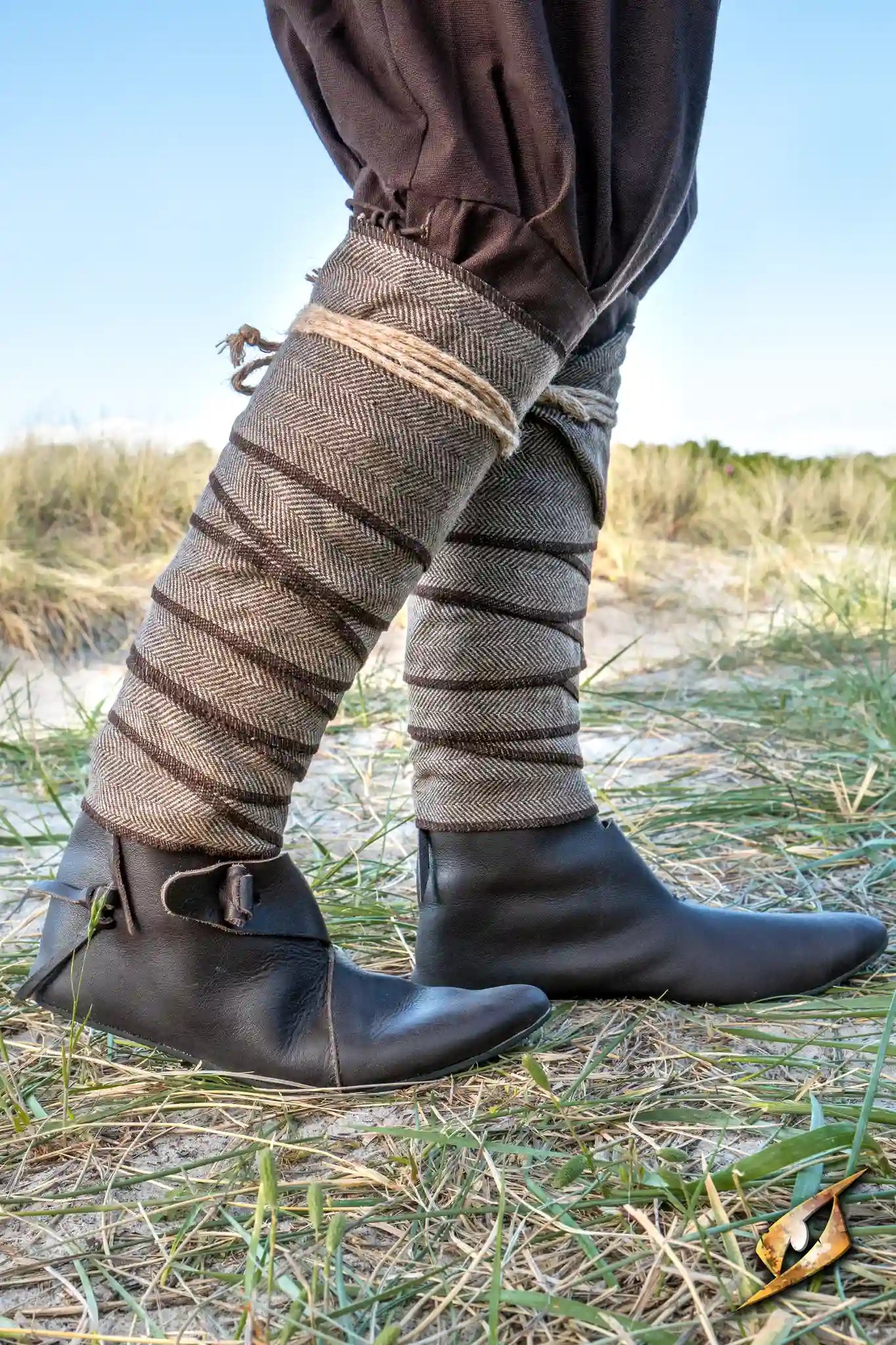 Herringbone Leg Wraps worn by a warrior, providing protection and style for LARP battles on a grassy field.