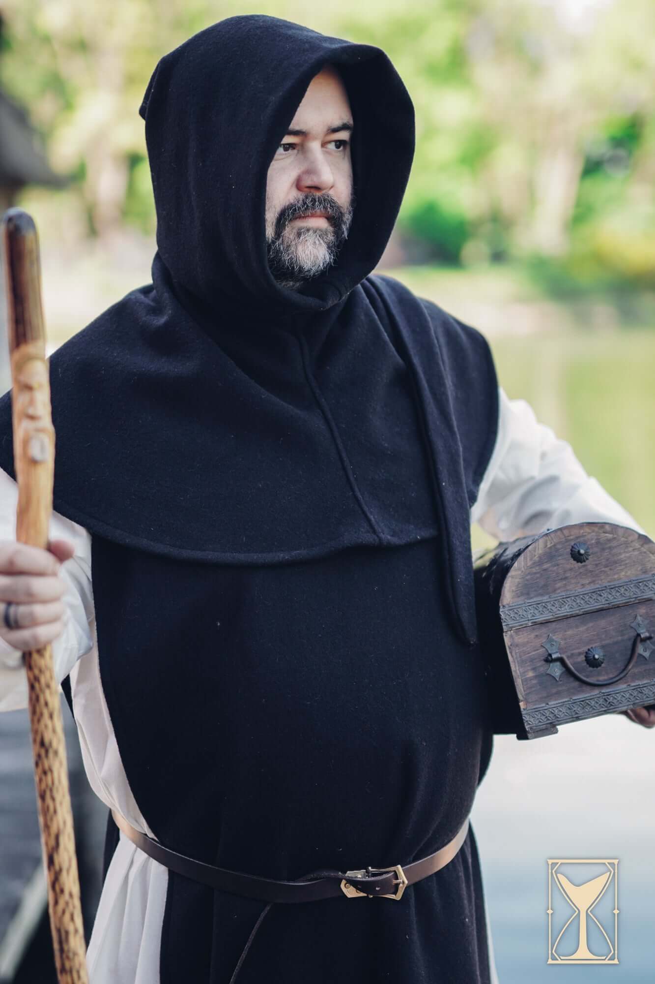 Simple Liripipe Hood - Brushed Wool worn by a medieval man holding a chest outdoors.