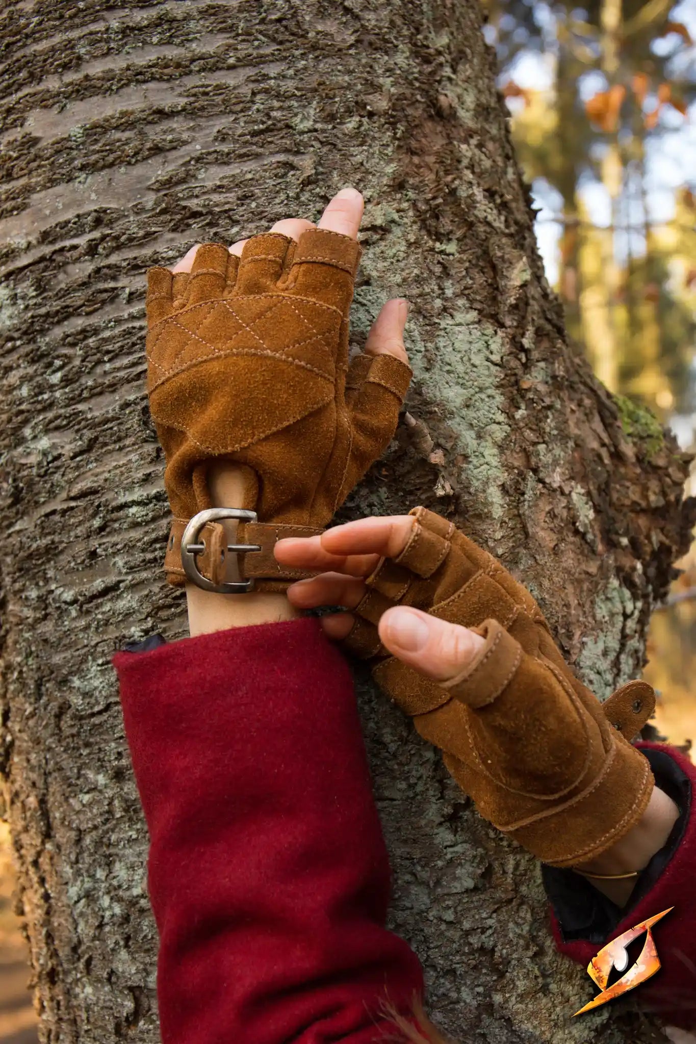 Celtic Gloves Suede on hands, showcasing ox brown color and fingerless design against a tree backdrop.
