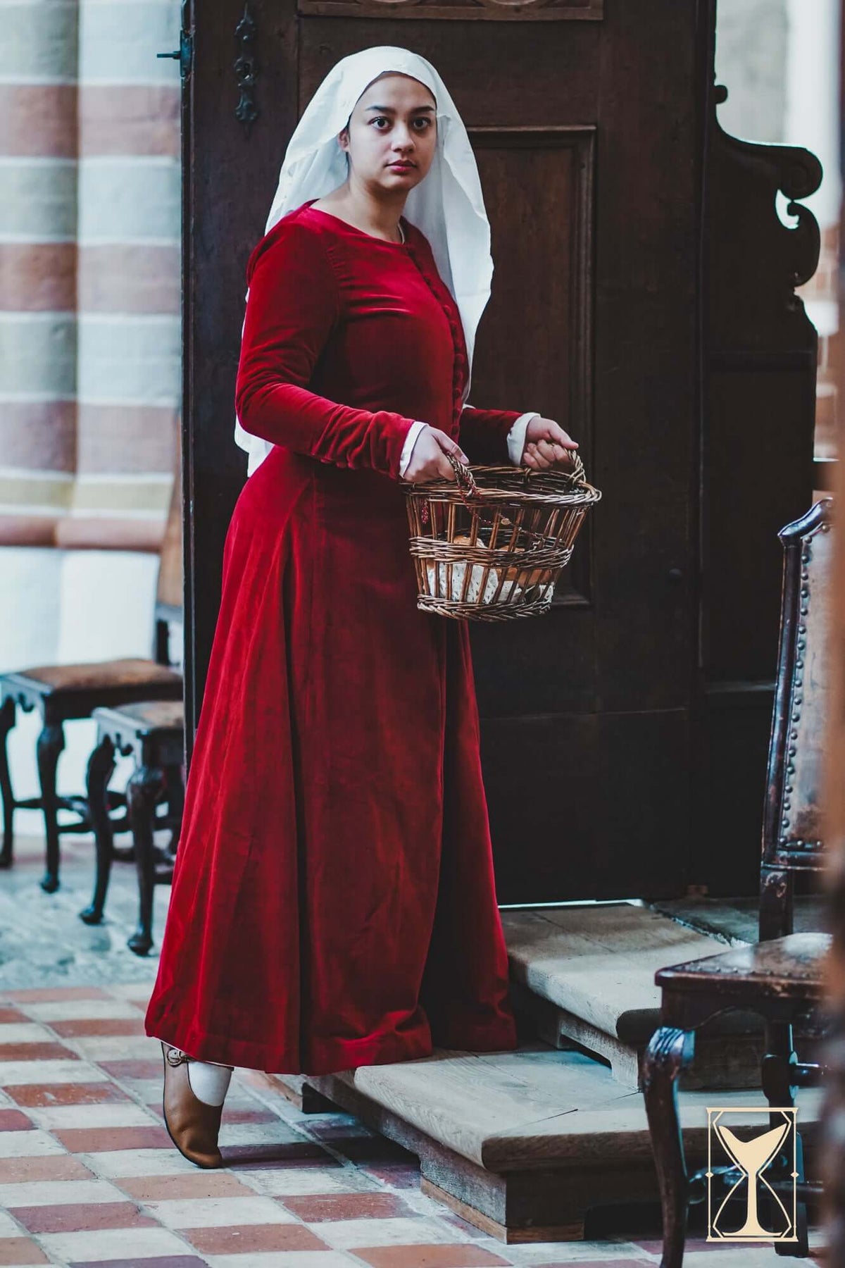 Cotehardie Colette worn by a woman holding a basket, showcasing its rich velvet design from the Yoremade collection.