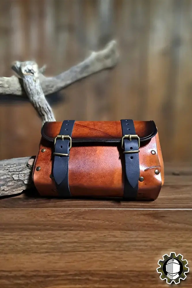 Beltbag Altair (Fighter) resting on a wooden surface, showcasing its stylish leather design and dual buckle closure.