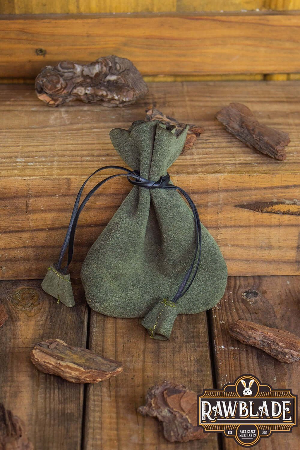 Alentorn Coin Bag displayed on a wooden surface, made of soft split leather with leather draw strings.