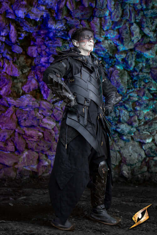 Portrait of a character in dark armor standing confidently against a colorful rocky background, showcasing detailed craftsmanship.