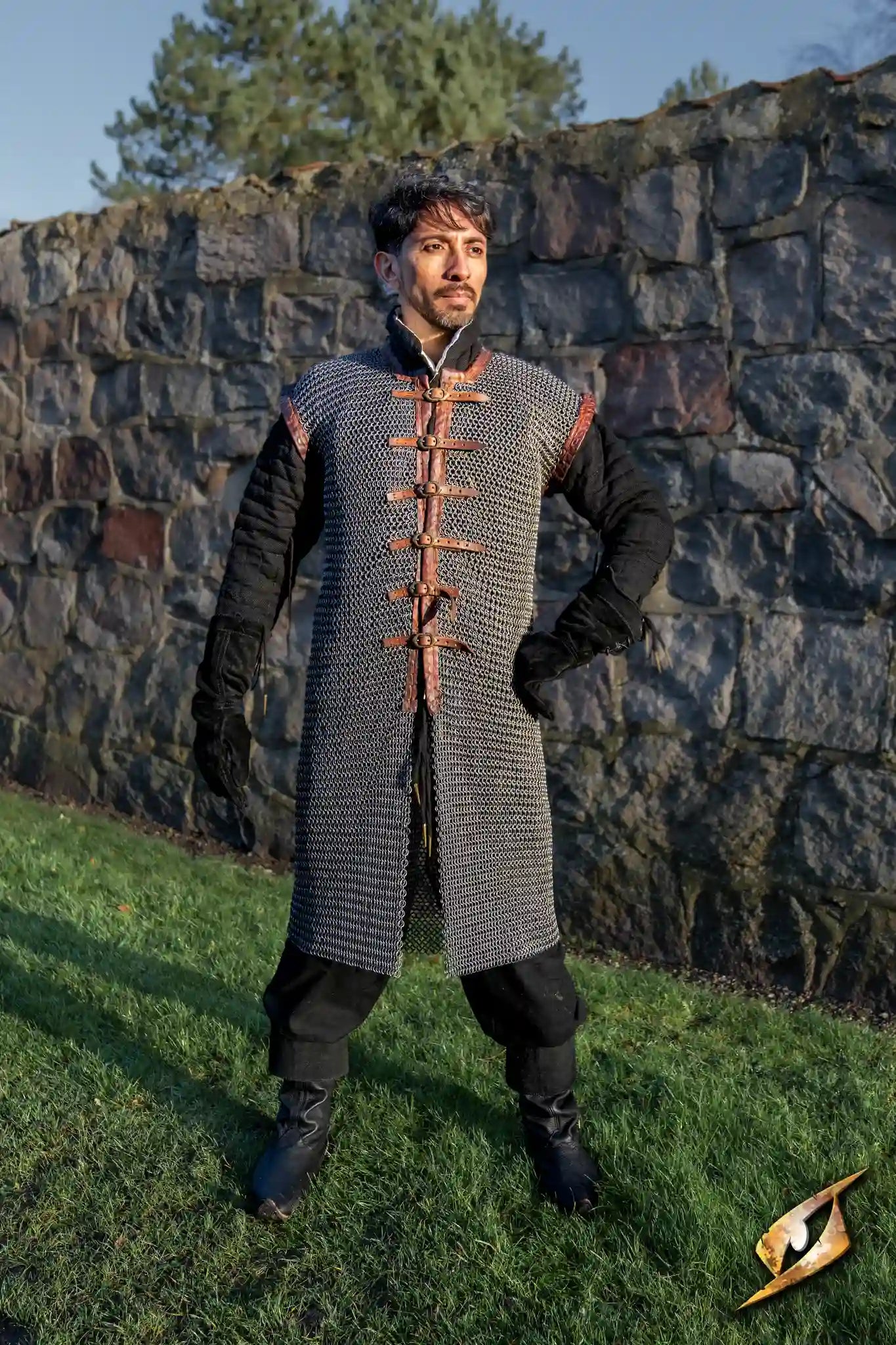 A person posing in a chainmail armor outfit, showcasing the historical chainmail craftsmanship.
