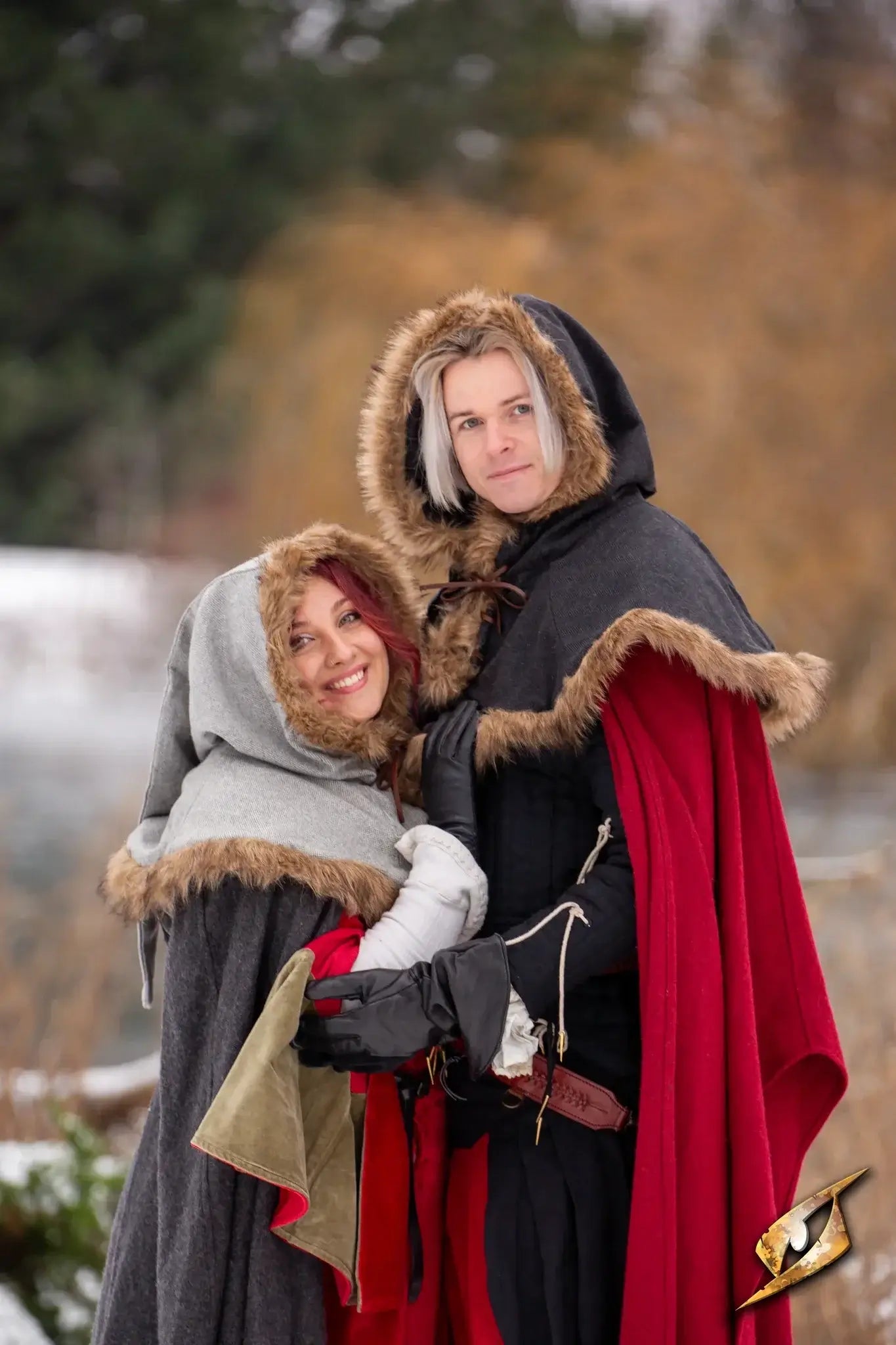 Couple wearing stylish LARP Clothing with fur-lined hoods on a snowy landscape.