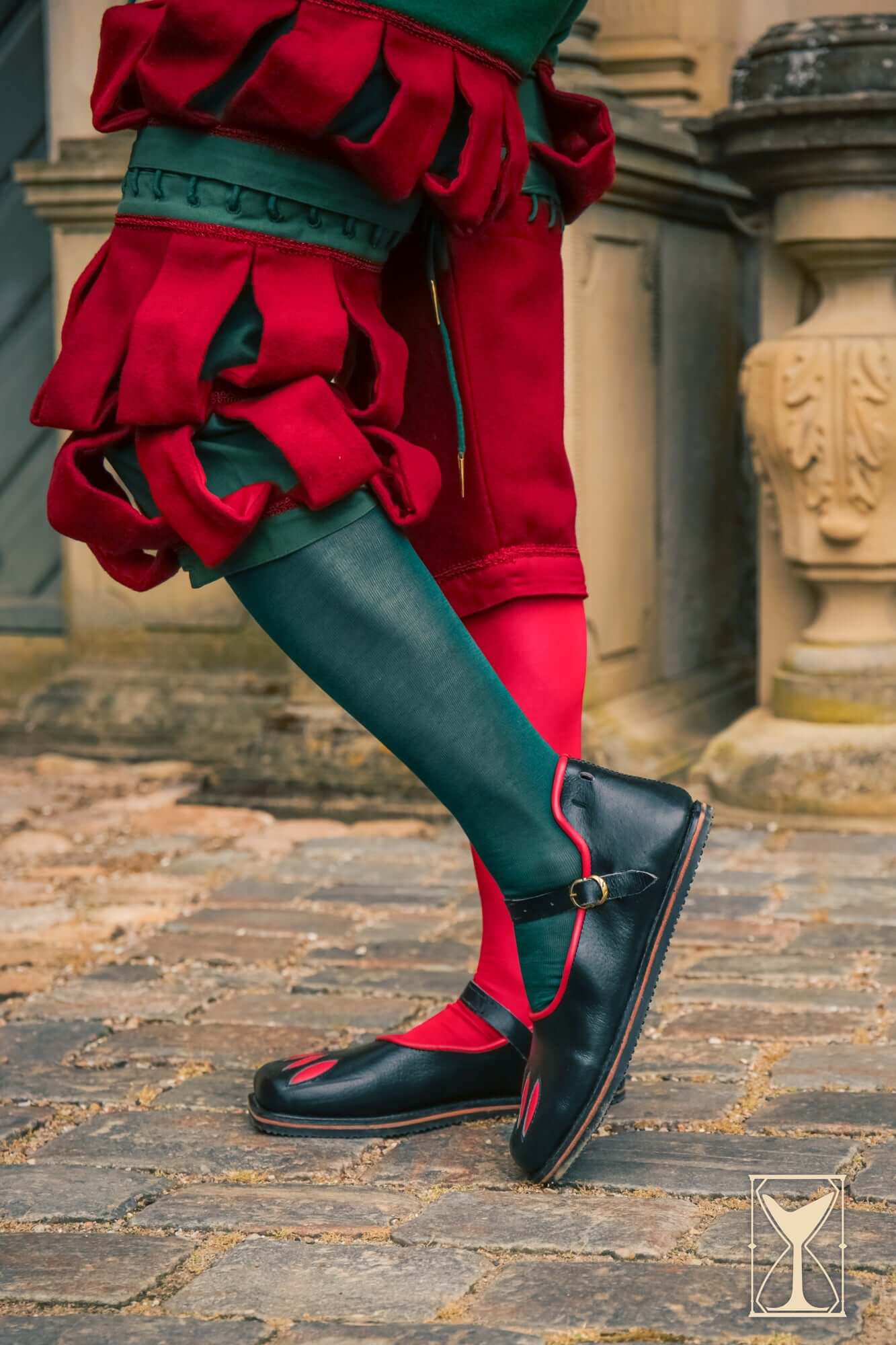 Renaissance and Medieval Footwear featuring black leather shoes with red accents, worn with colorful medieval attire.