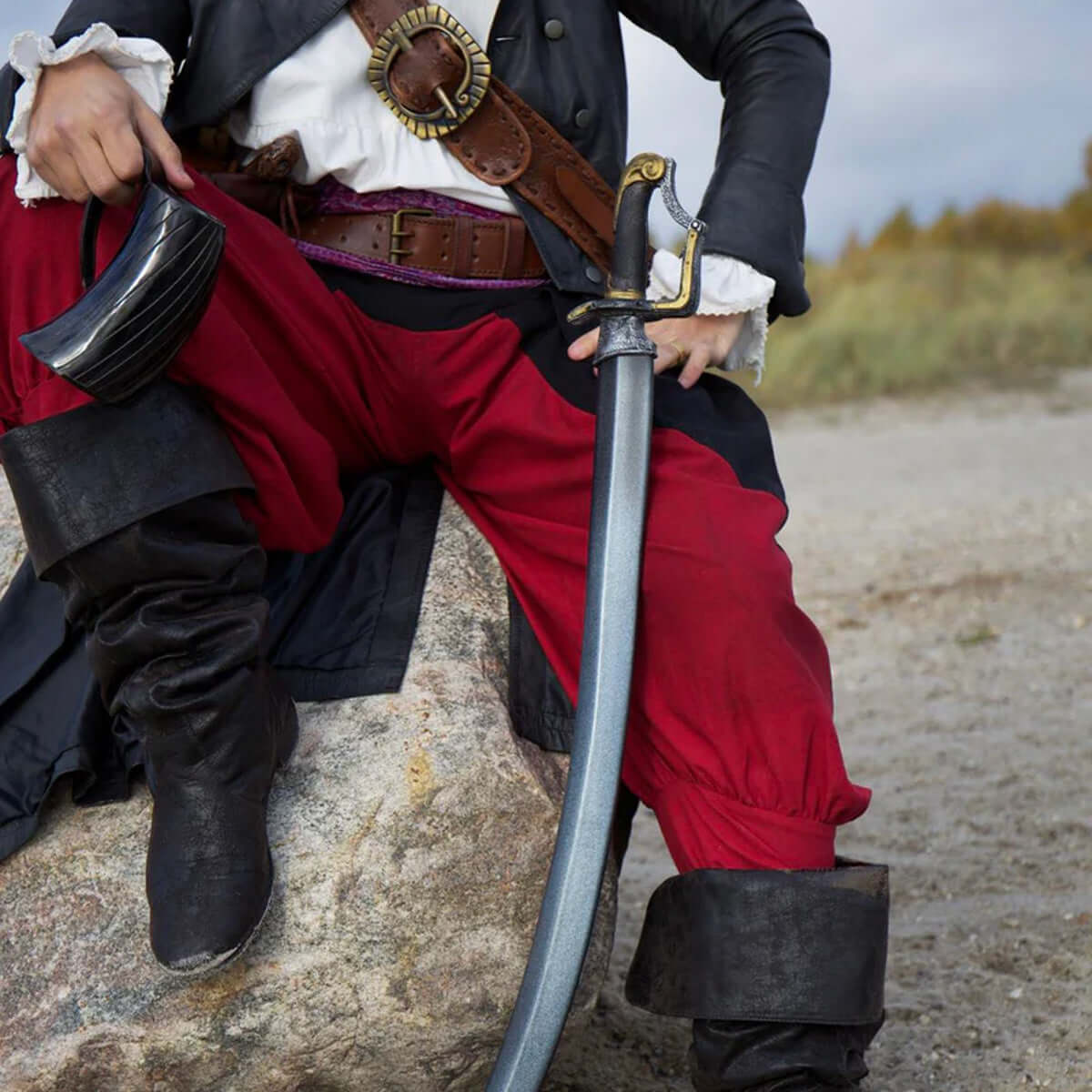 Pirate dressed in red pants holding a curved sword, showcasing Curved Swords for cosplay and reenactments.