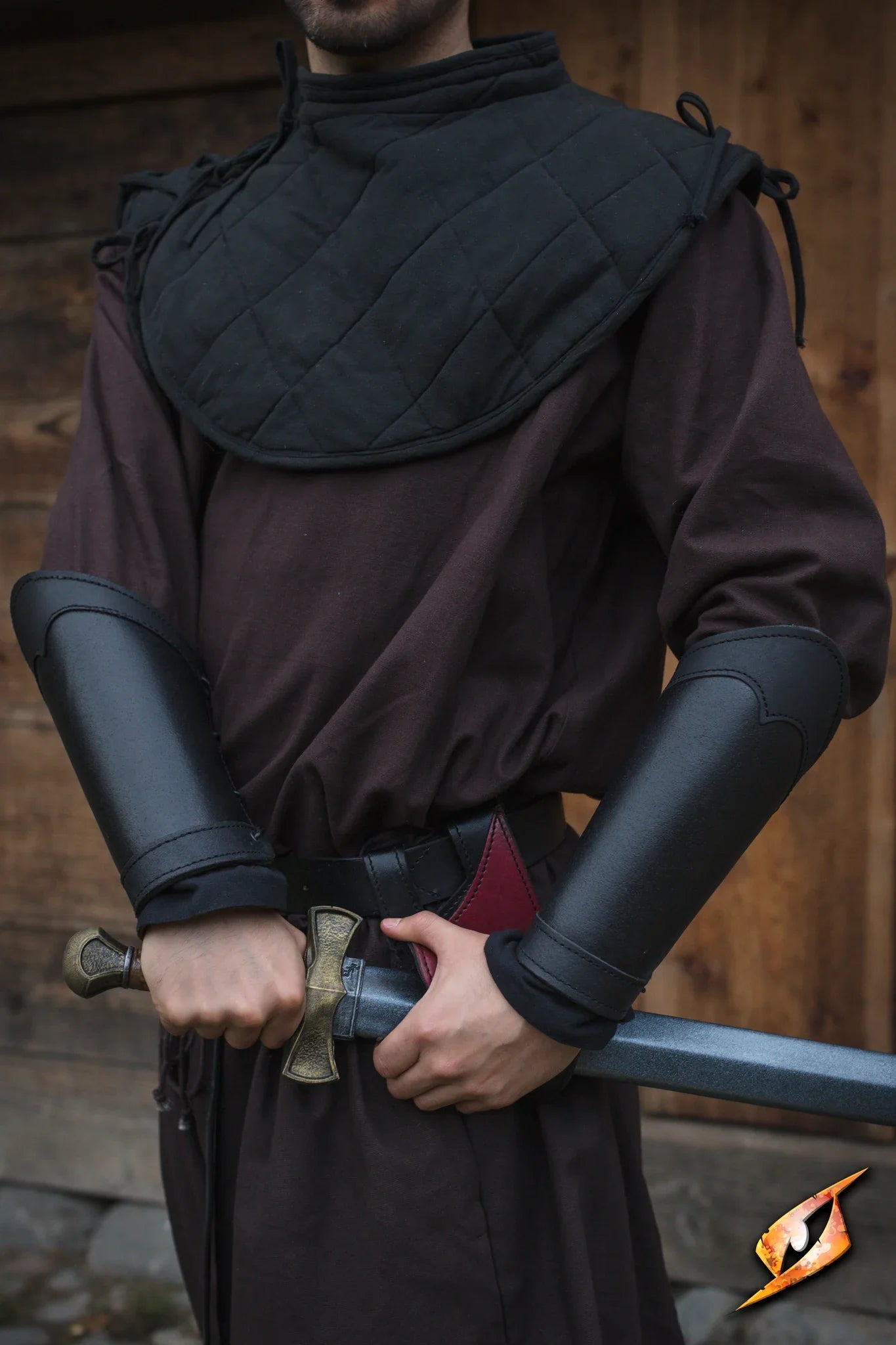 Bracers Warrior worn by a medieval fighter holding a sword, showcasing durable black leather arm guards.