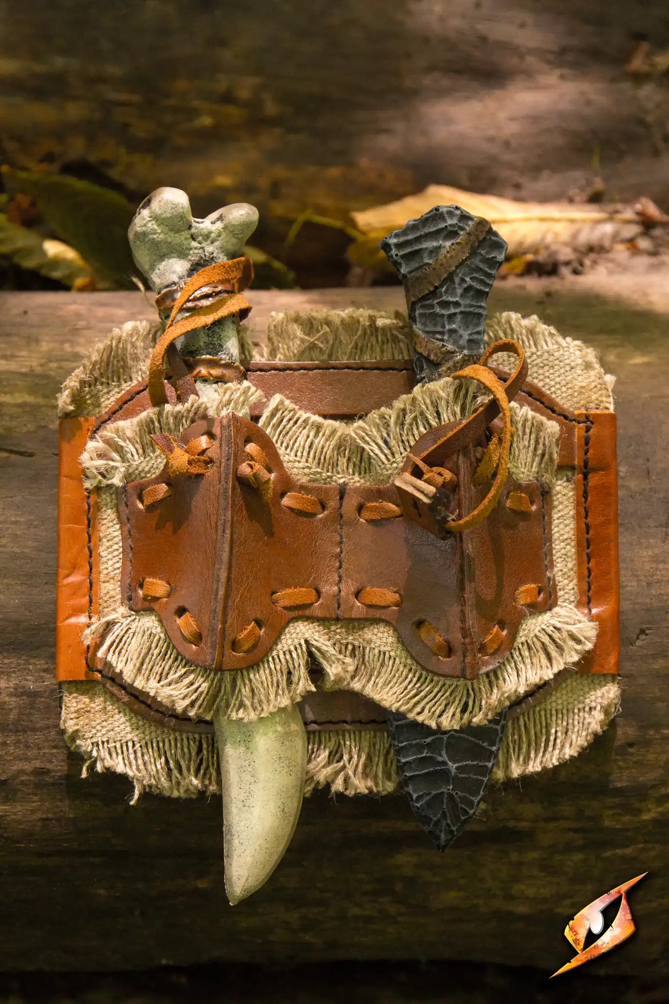 Wildling Set Holder with Bone knife and Stone knife, handmade in ox brown color, attached to a rustic background.