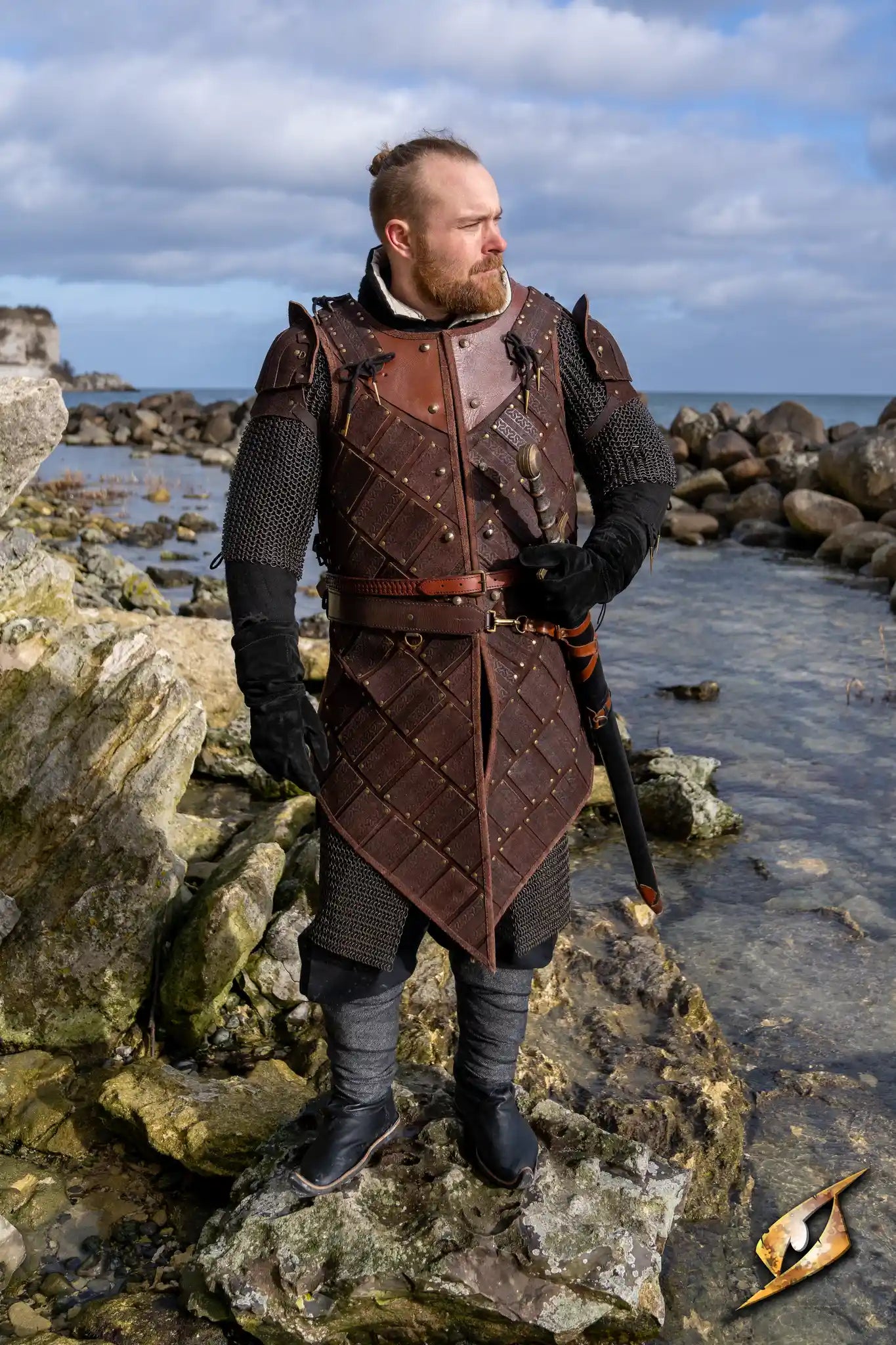 Woodsman Armour Suede in dark brown, worn by a warrior standing on rocks by the water, ideal for comfort and fit.