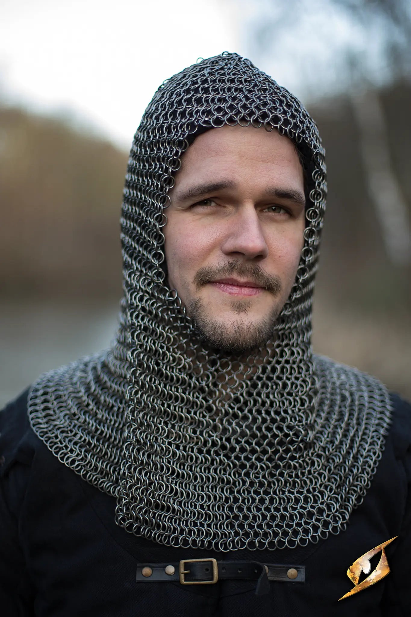 Chainmail Hood - Alaric worn by a man, showcasing medieval armor and protection in a rugged outdoor setting.