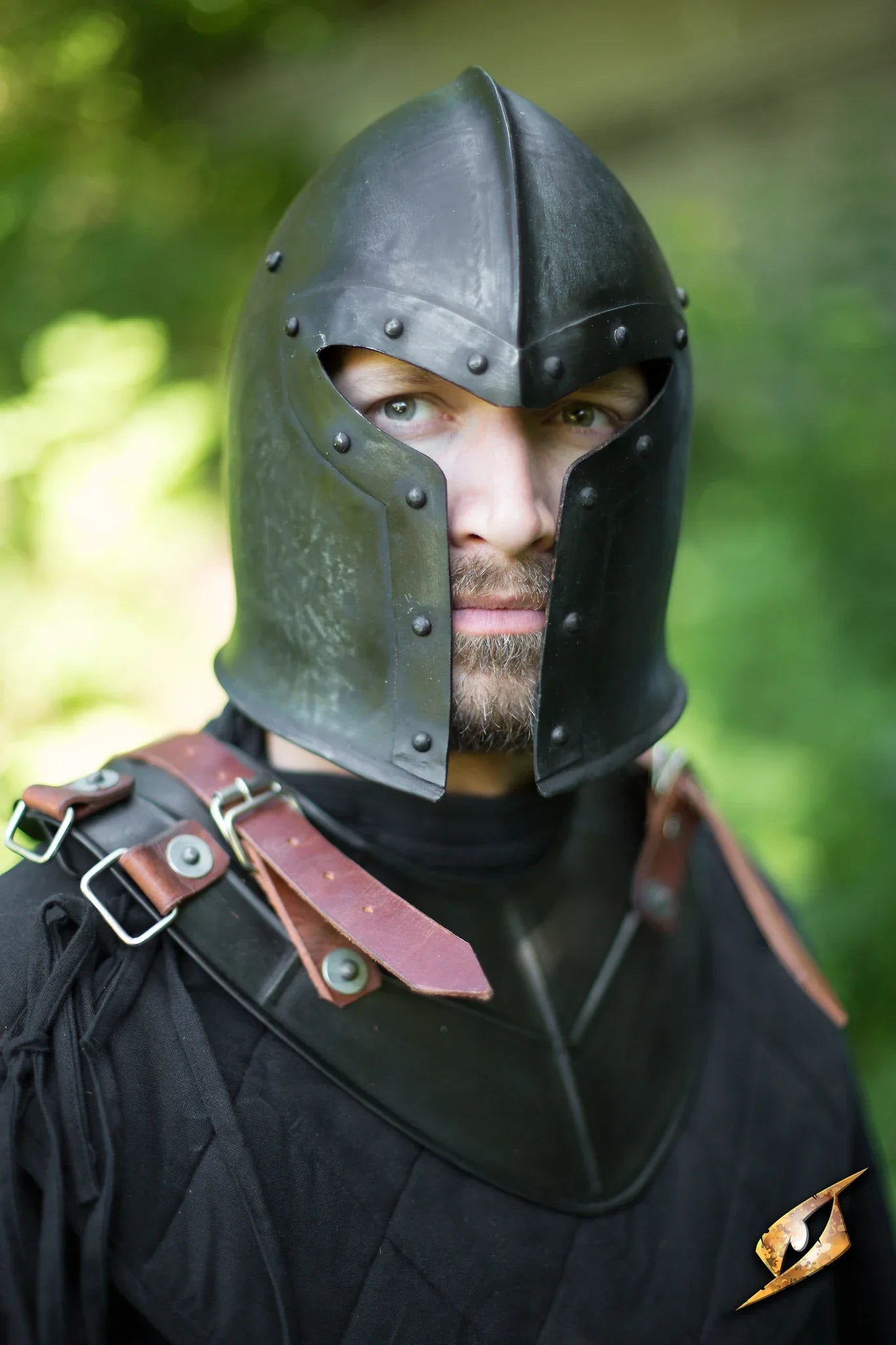 Close-up of a soldier wearing a Barbuta helmet, showcasing detailed craftsmanship and historical design, outdoors.