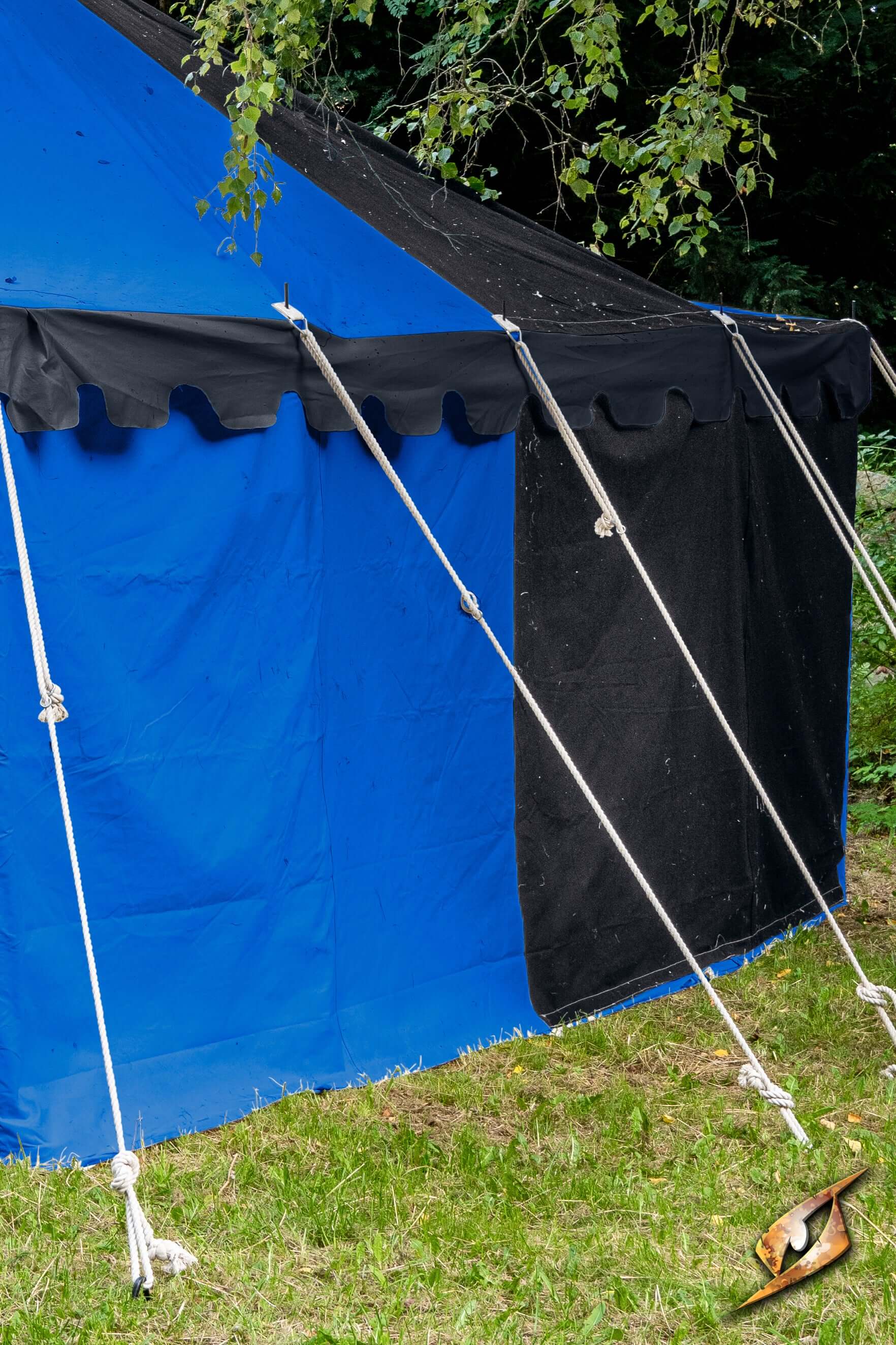 Marquee Tent - Sides - 5x8m with blue and black fabric showcasing sturdy poles and guylines in a grassy area.