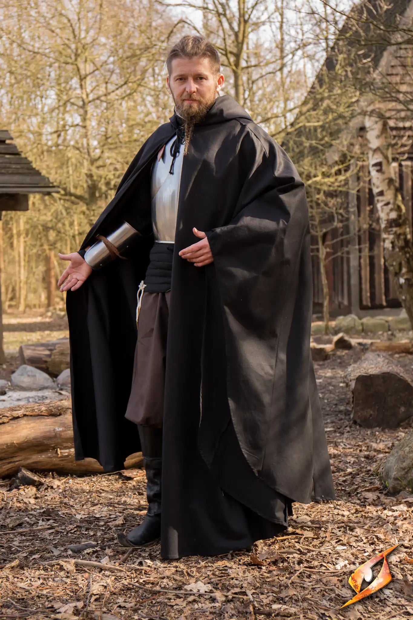 Model wearing the Cape Godfrey Twill, a mobility-friendly ankle-length cape with a hood and cotton-strap fastenings.