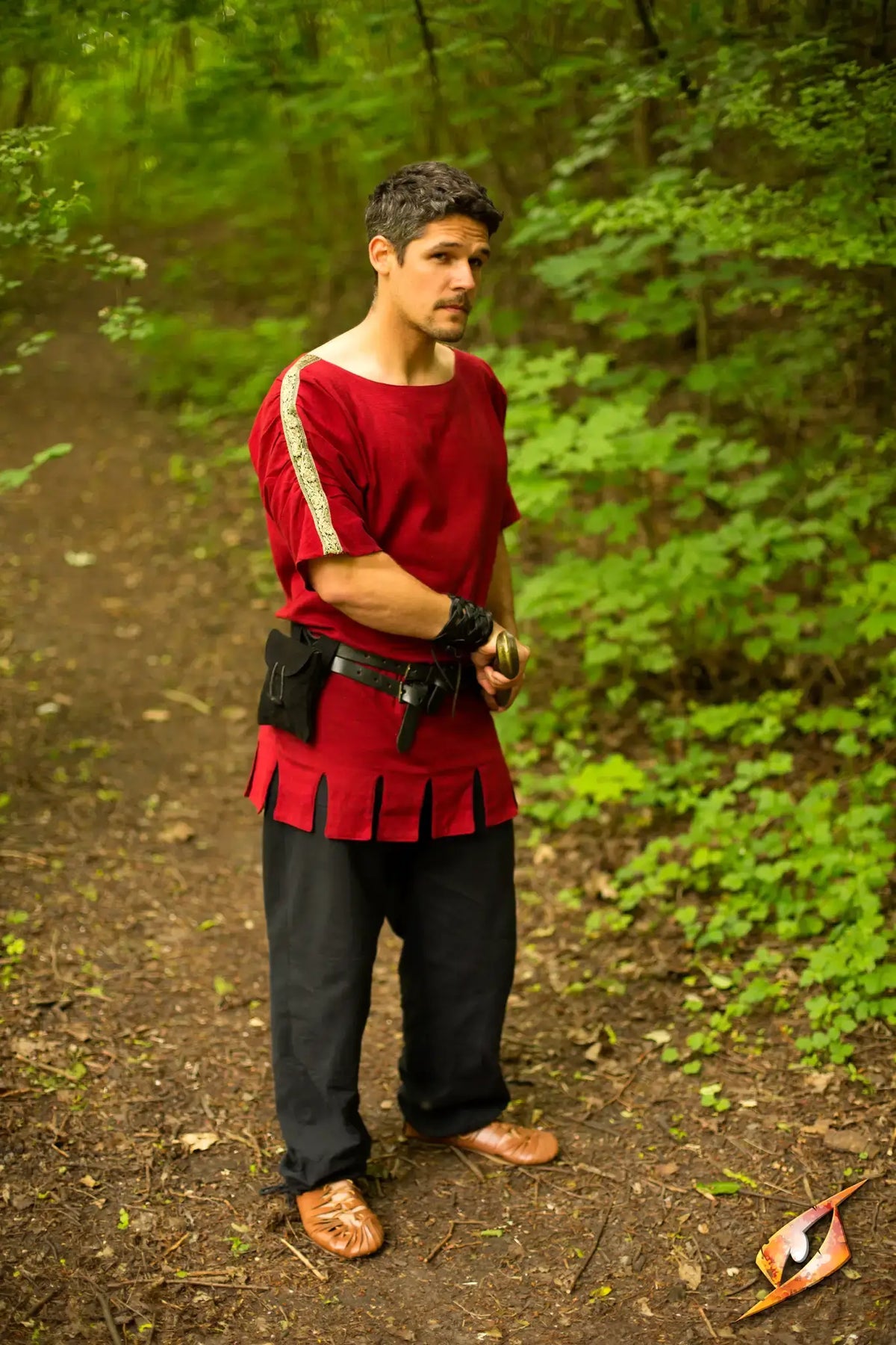 Man wearing a Roman Tunic in a lush forest setting, showcasing Roman style and culture.