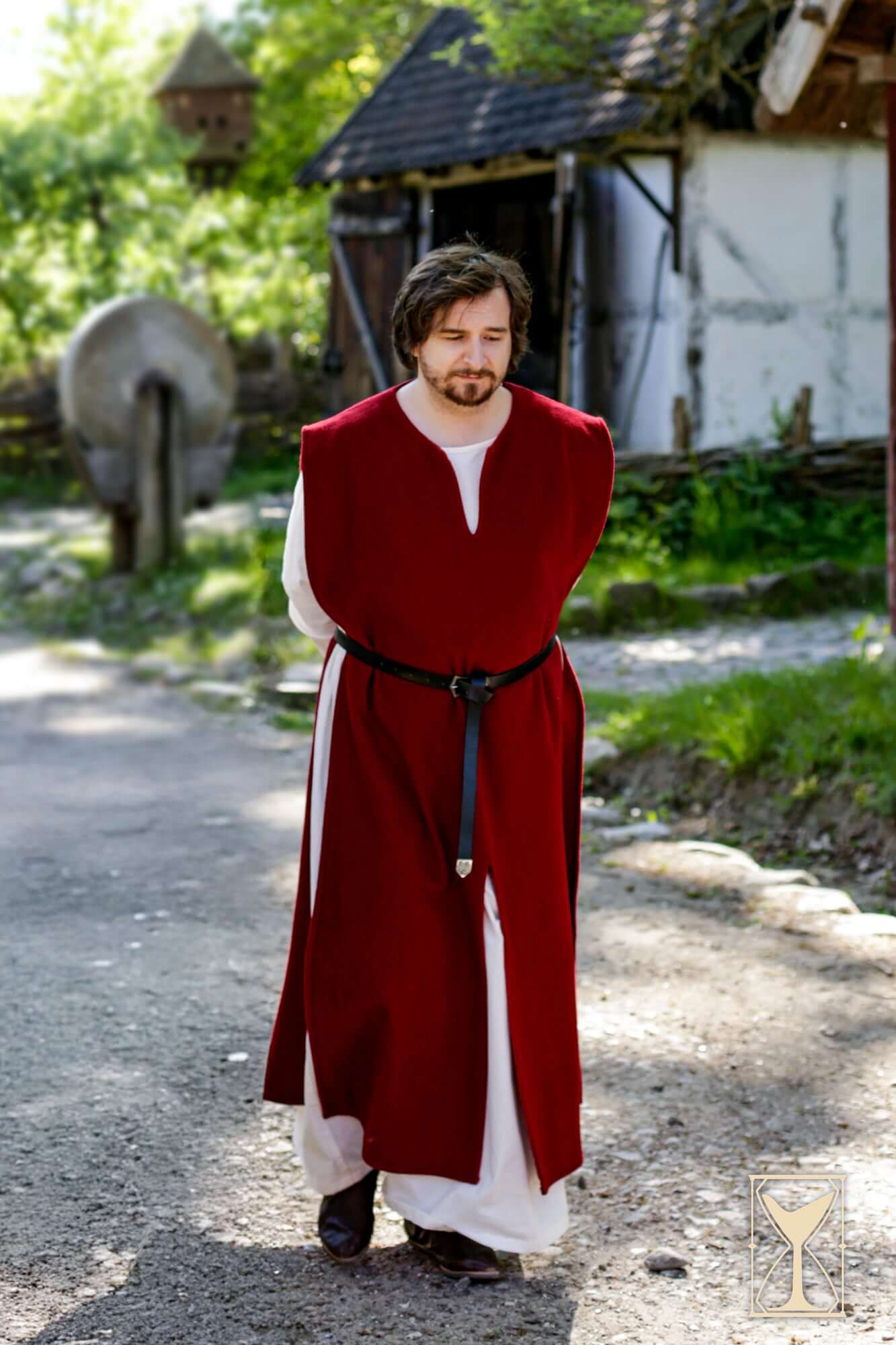 Cyclas Bernard medieval sleeveless over-tunic worn by a man in a natural outdoor setting.