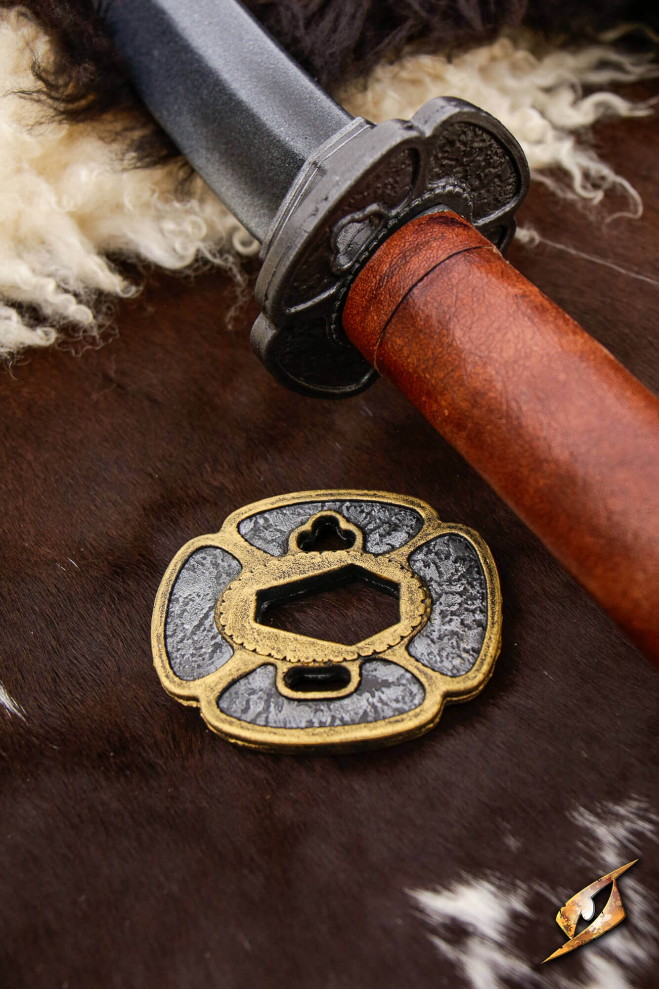 Mokko-gata Tsuba displayed beside a Ryugan Katana on a textured surface.
