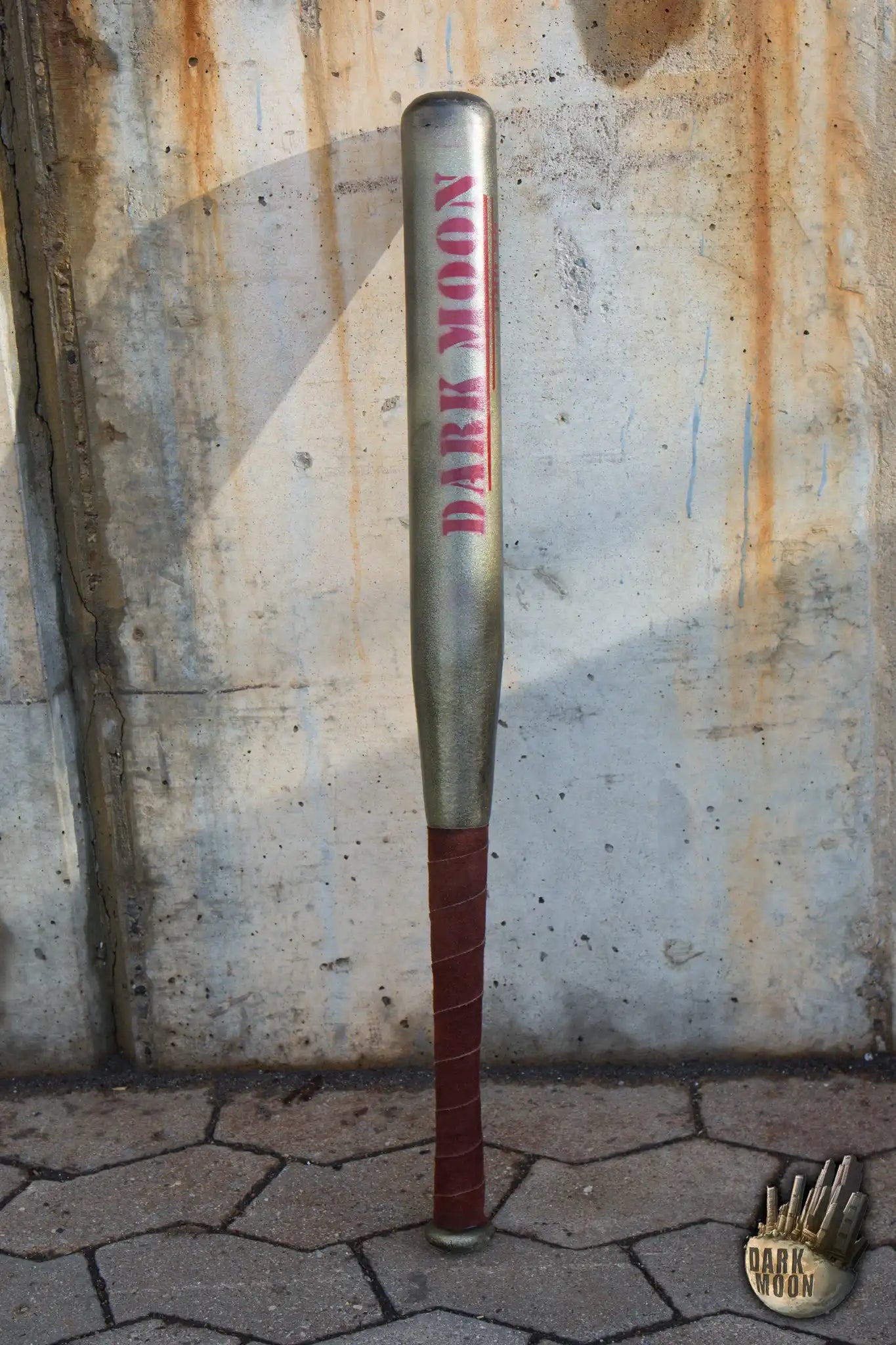 Baseball Bat with 'DARK MOON' logo leaning against a concrete wall, ideal for defense against zombies.