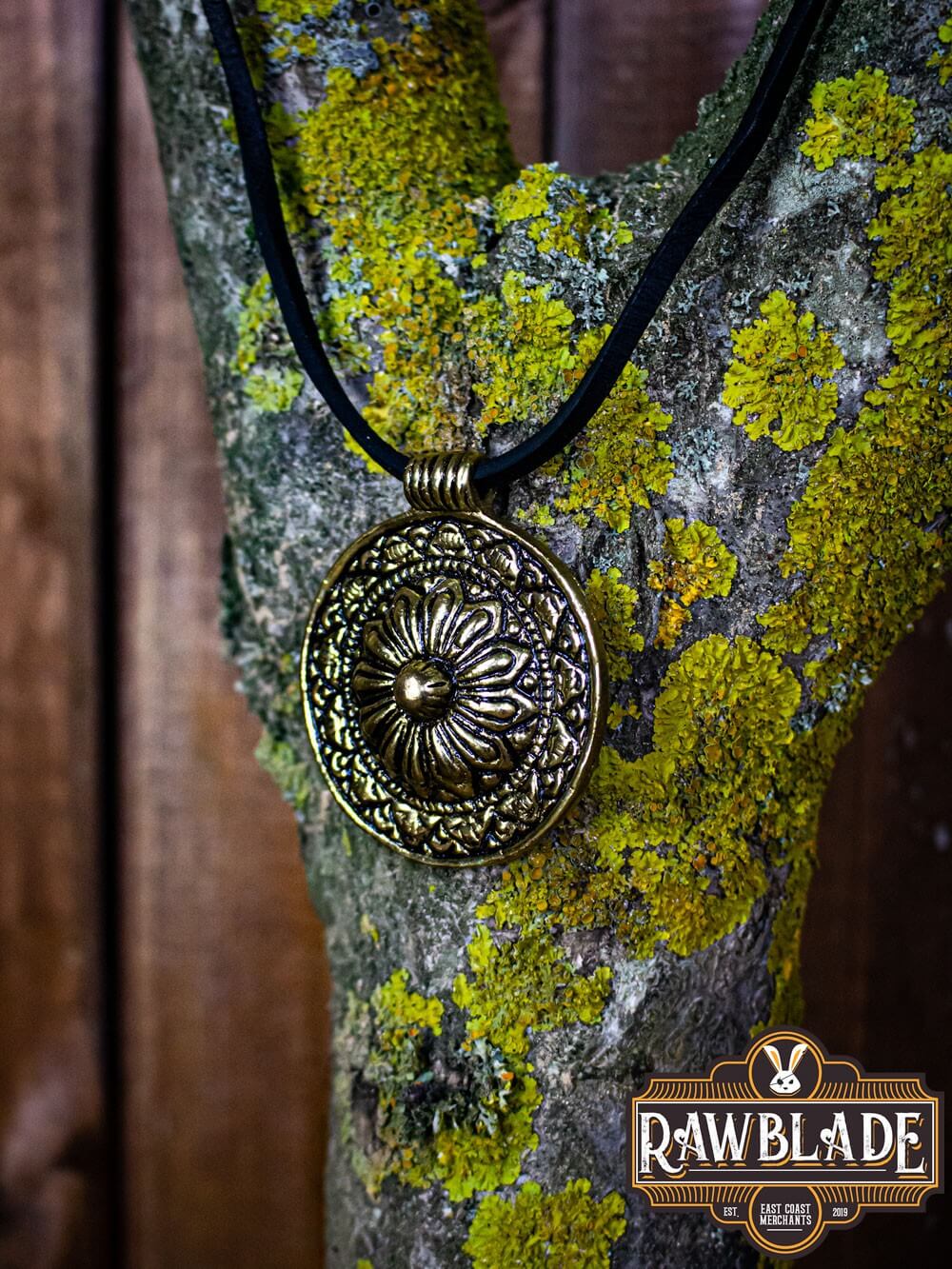 Capadocian Amulet displayed on a tree trunk, featuring intricate floral design and a circular shape.